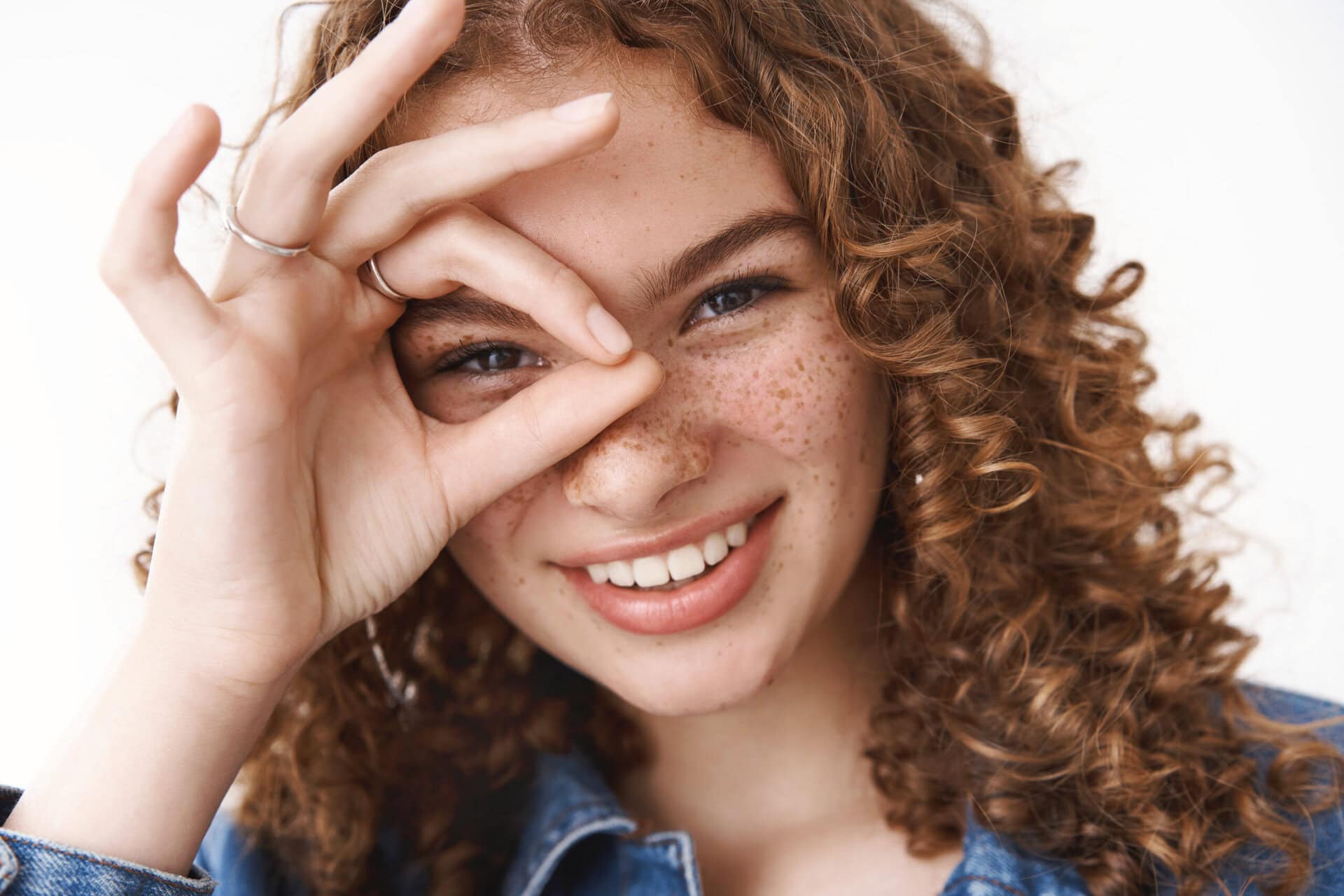 Headshot happy lucky positive young girl show okay ok sign aroun